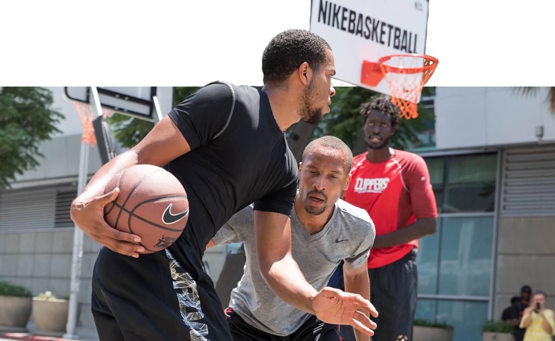 Two adult-division players face off on the Nike 3-on-3 basketball court.